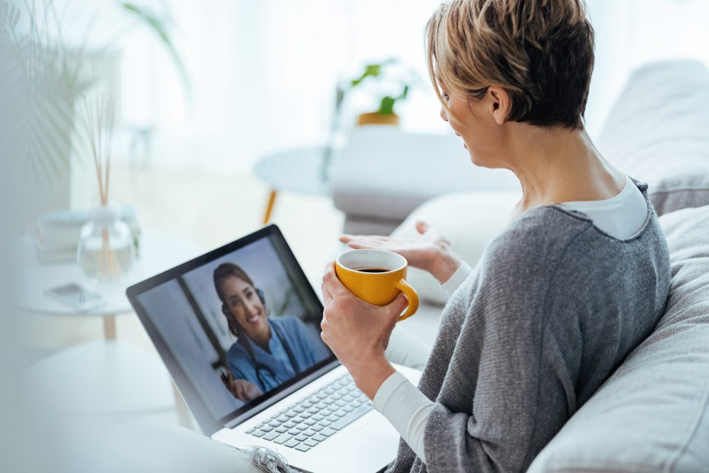 Woman Using Laptop And Having Video Call With Her Doctor While Sitting At Home.